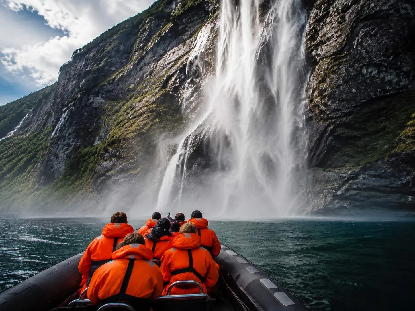 A RIB safari boat near the waterfalls on the Geirangerfjord